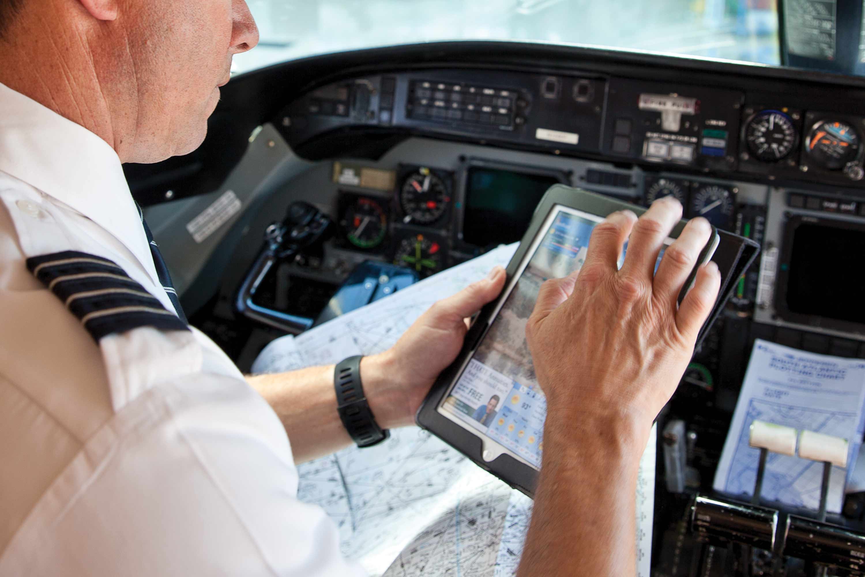 Pilot using a tablet electronic flight bag in an aircraft cockpit